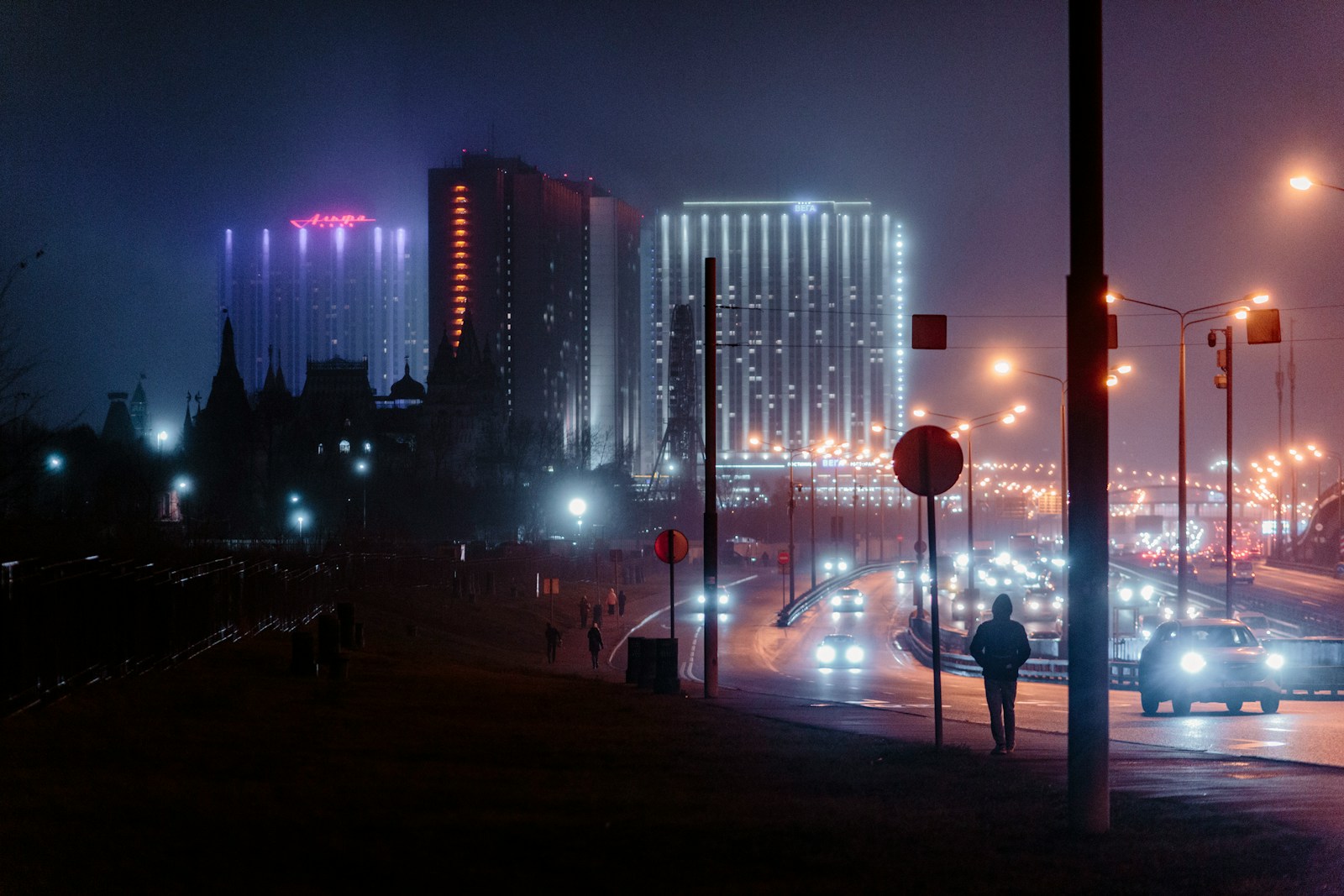 Cityscape at night with glowing buildings and traffic.